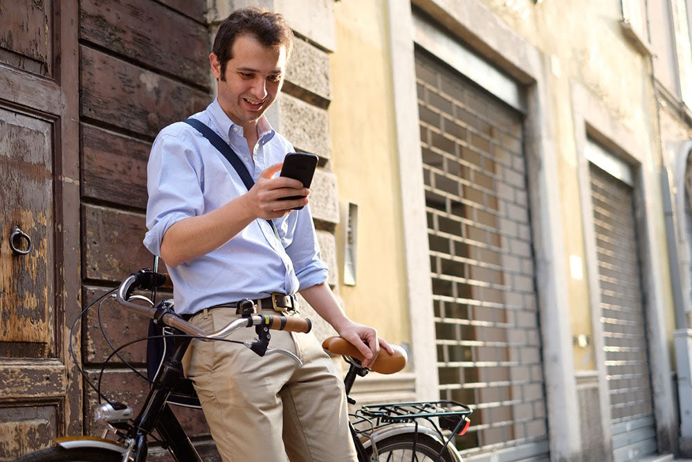 Mann mit Smartphone und Fahrrad