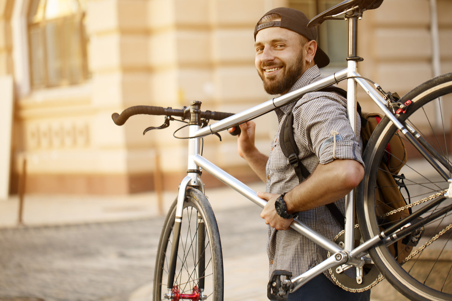 Mann trägt Fahrrad auf Schulter